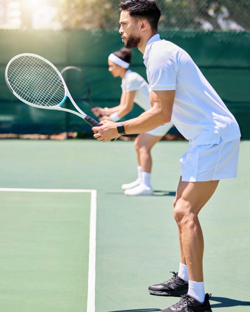 Fitness, teamwork and couple in a tennis partnership for a doubles workout game or training match in summer. Wellness, focus and healthy man playing on a tennis court outdoors with a sports partner.