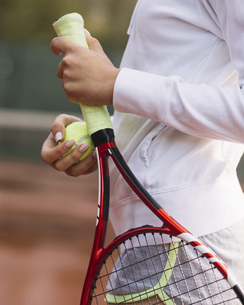 sportive-woman-holding-tennis-racket-with-ball