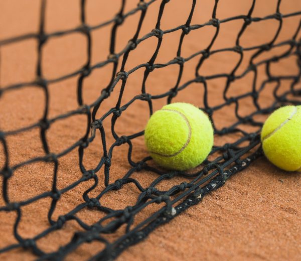 two-tennis-ball-near-black-net-ground